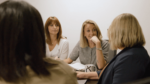 Four female directors of client strategy in a meeting, engaged in conversation around a table.